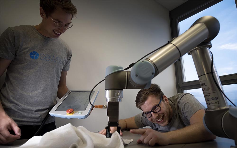 Automated feeding of flat laundry onto industrial folding machines